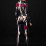 Women in skeleton bodysuit with red roses and floral cloak, Day of the Dead-inspired, with sugar skull makeup and red rose crown.
