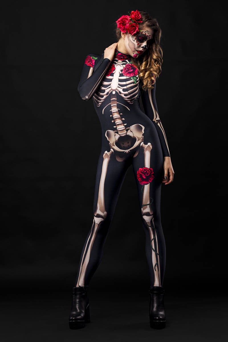 Women wearing a skeleton bodysuit with red rose accents and matching floral cloak, styled for Halloween. The outfit is inspired by Day of the Dead with intricate sugar skull face makeup and a crown of red roses.