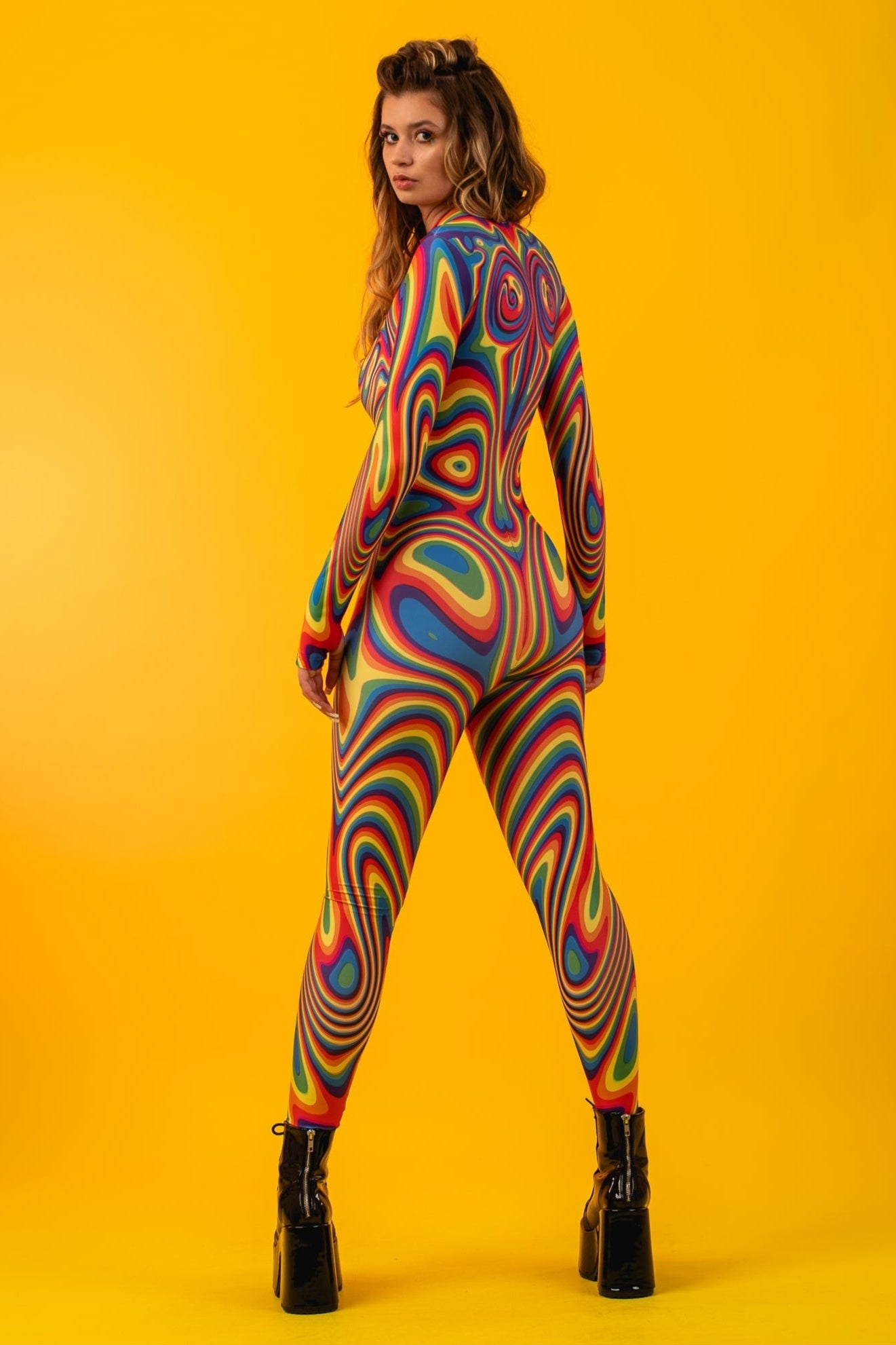 Rear view of the Rainbow Liquid Catsuit with model turning her head, highlighting playful elegance and full body rainbow design.