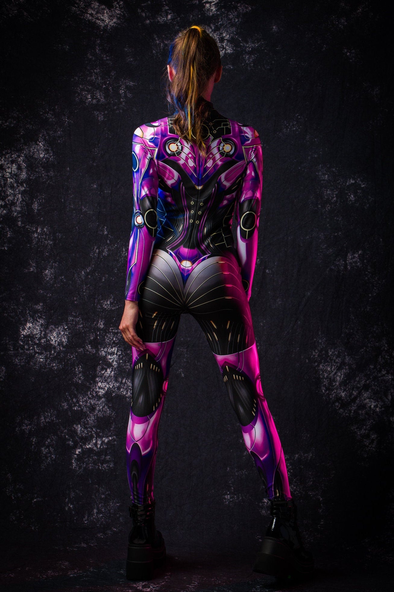 Rear view of a woman in a violet full body android catsuit costume, highlighting detailed design and comfortable fit for Halloween and cosplay.