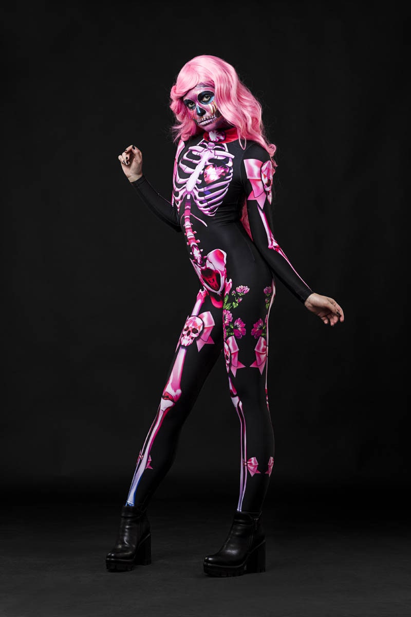Woman posing in the Pink Sugar Skull Skeleton Halloween costume, highlighting the vibrant pastel pink skeleton design and sugar skull theme, great for Halloween or as a unique festival outfit.