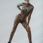 Dynamic front pose with wide stance in LEOPARD SPOTS Tattoo Catsuit for Women – model wearing sunglasses, energetic look.