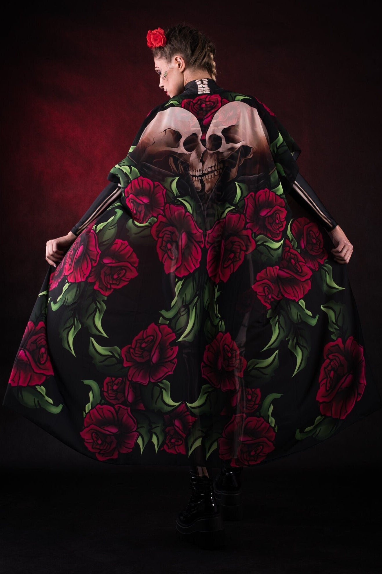 Woman wearing the Lady Death kimono Halloween cape, featuring a black cape with skull and rose accents, perfect for Halloween or Day of the Dead events.