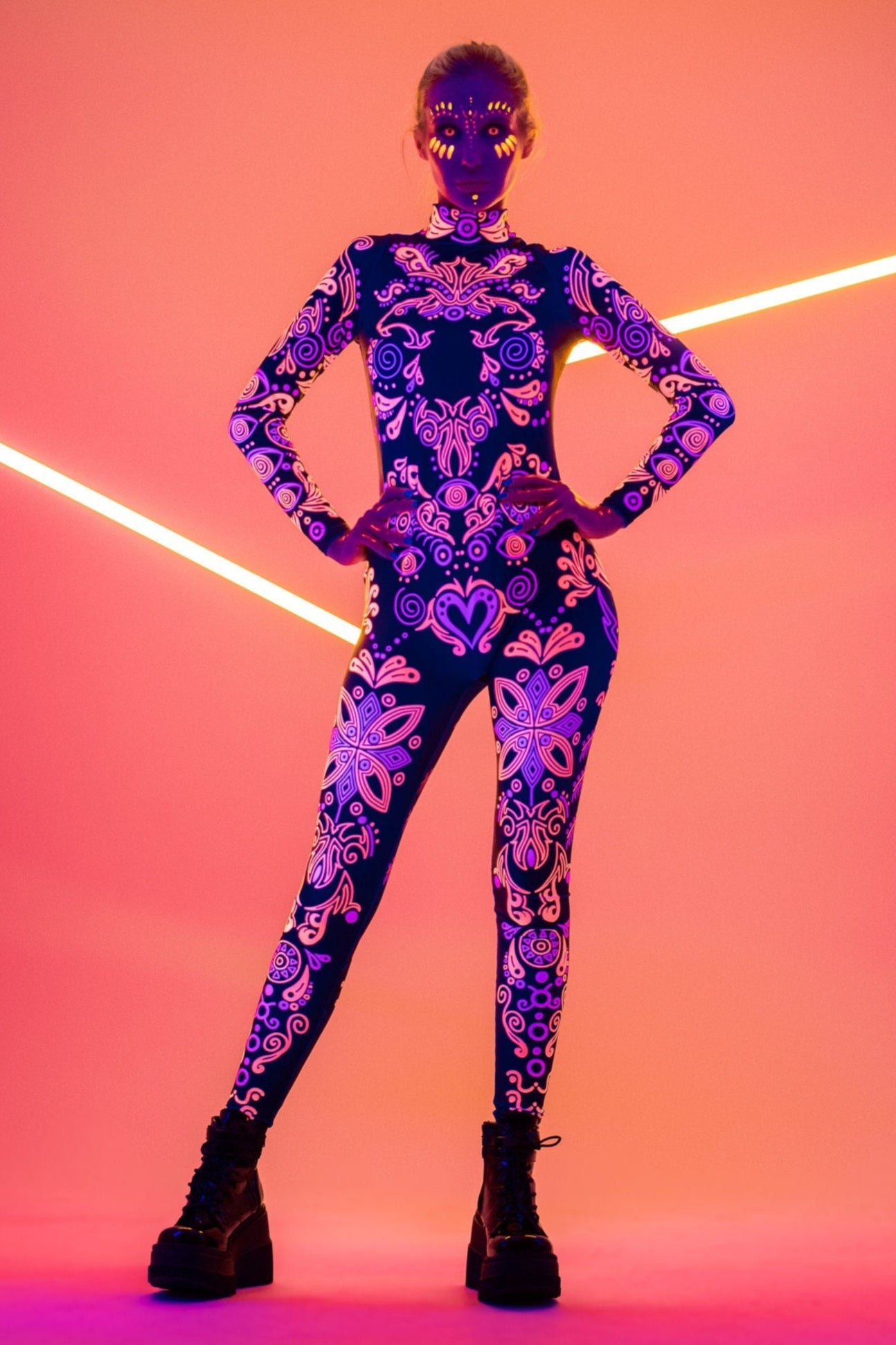 Front view of the SUNSET VOLTAGE UV Reactive Catsuit glowing under blacklight – bold fluorescent design perfect for raves and festivals.