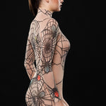 Model wearing the Spiderweb Halloween bodysuit, a mesh catsuit with intricate spiderweb tattoo effect, perfect for Halloween or gothic-themed events.