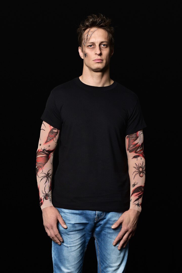 Man posing in the Spiders Halloween T-shirt with tattoo sleeves, showcasing the spooky spiderweb and bloody tattoo design, perfect for Halloween or as a unique statement shirt.