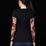 Woman posing in the Spiders Halloween T-shirt with tattoo spiderweb sleeves, showcasing the spooky sleeve design, perfect for Halloween or as a unique statement top.