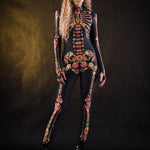 Woman posing in the Flower Skeleton costume, showcasing the colorful skeleton design with orange, yellow, and green floral patterns, great for Halloween or as a standout festival outfit.