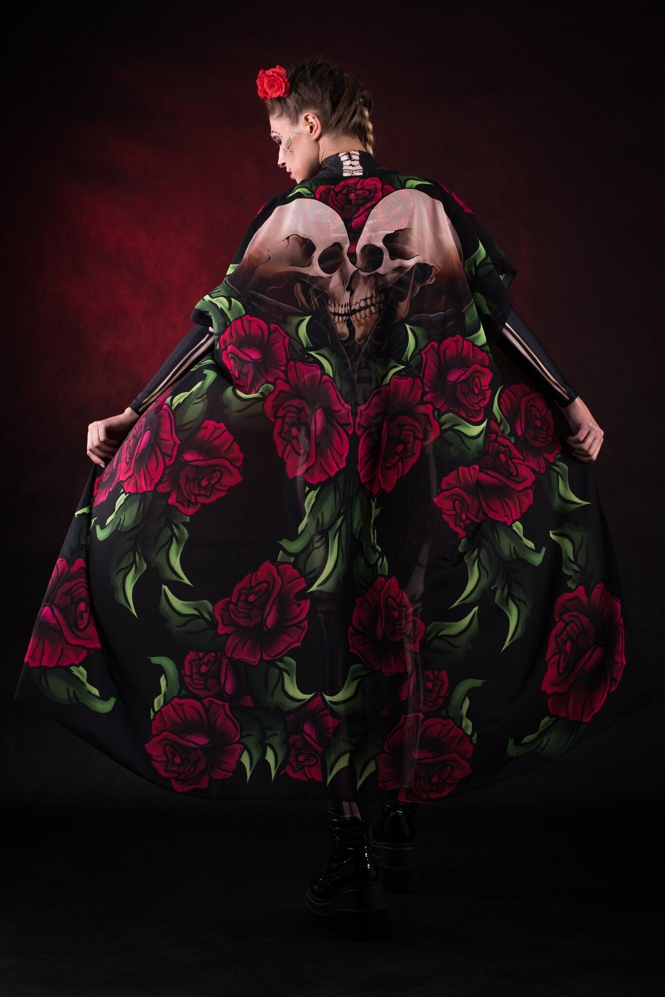 Woman wearing the Lady Death kimono Halloween cape, featuring a black cape with skull and rose accents, perfect for Halloween or Day of the Dead events.